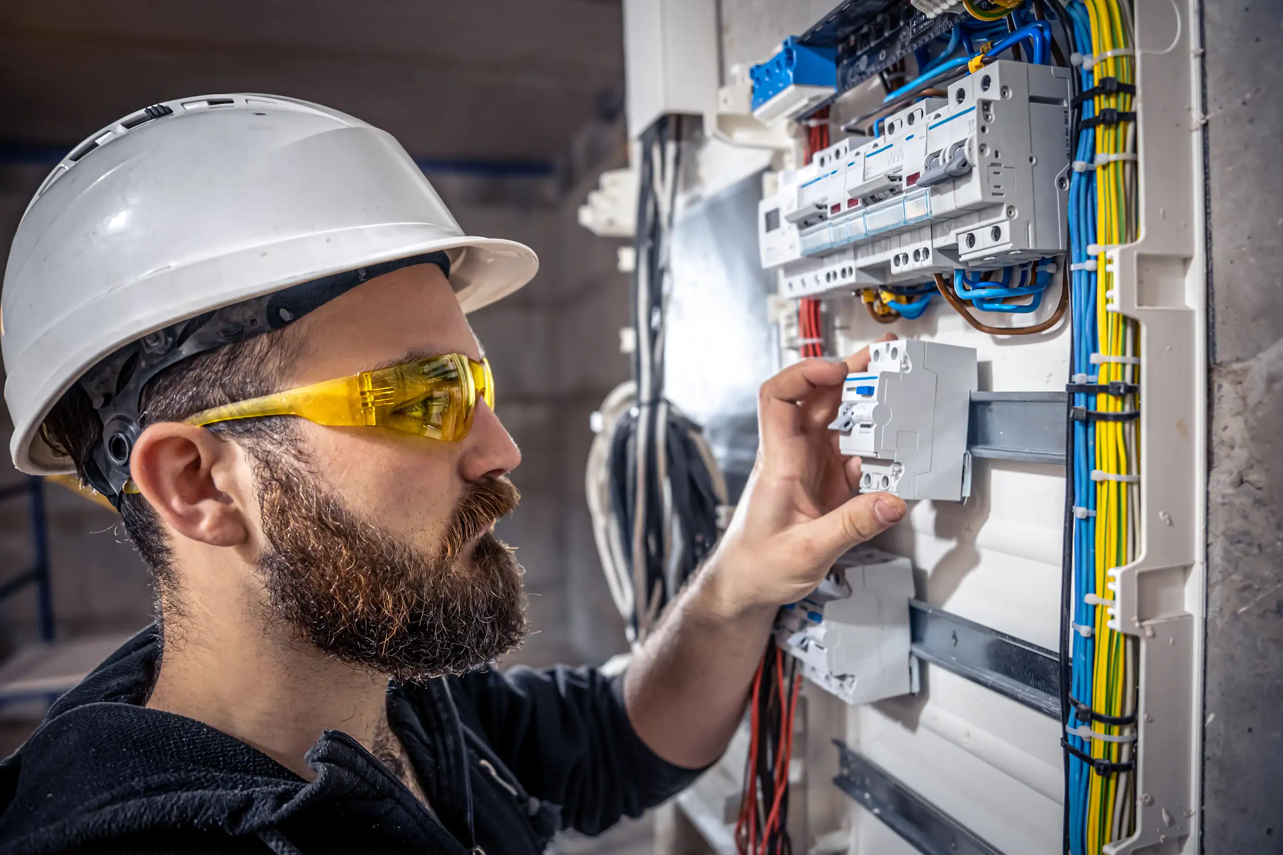 An electrician checking and installing a device