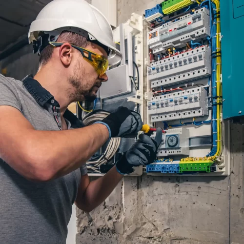 A professional technician checking and trying to fix an electric station